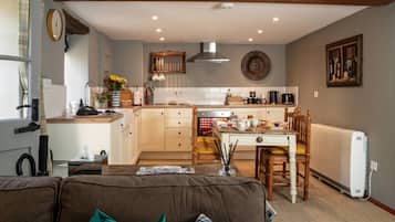 A cozy kitchen with a dining area, wooden furniture, and a radiator.