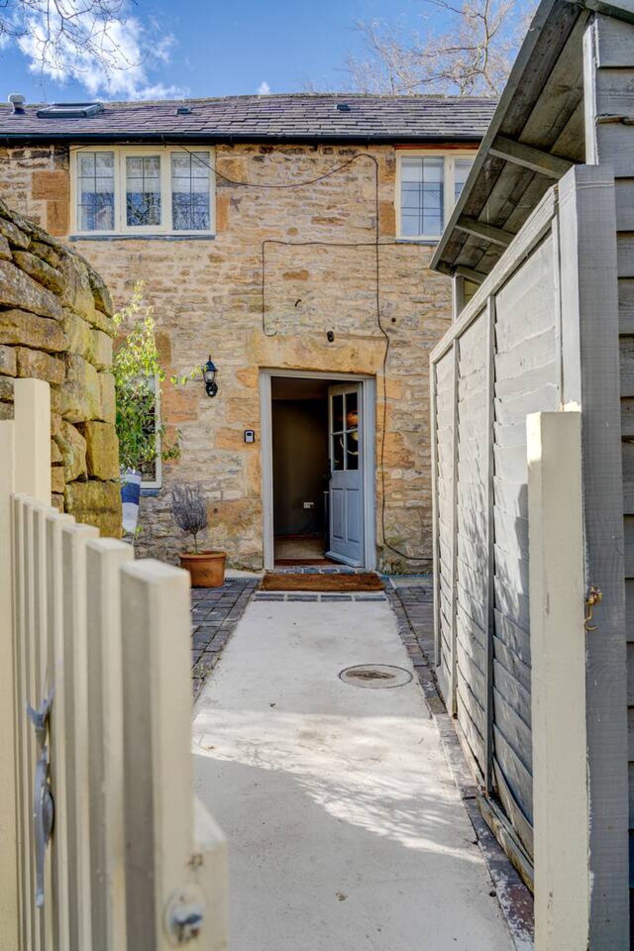 A stone building with a door leading to a covered entrance.