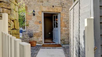 A stone building with a door leading to a covered entrance.