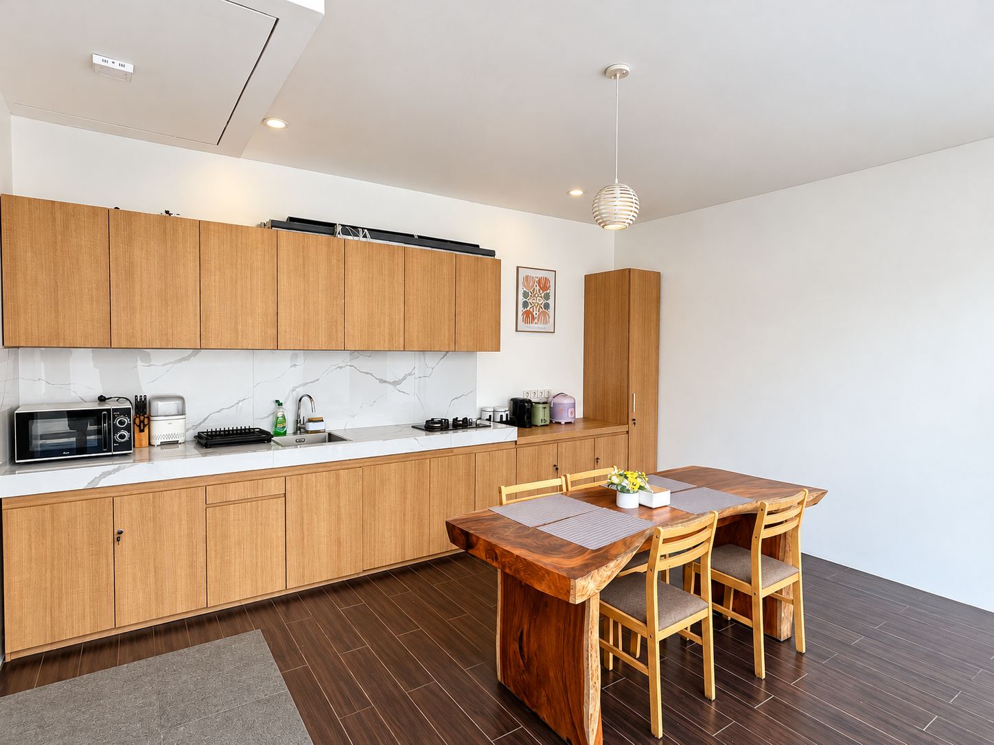 A modern kitchen with wooden cabinets, a marble backsplash, and a dining area with a wooden table and chairs.