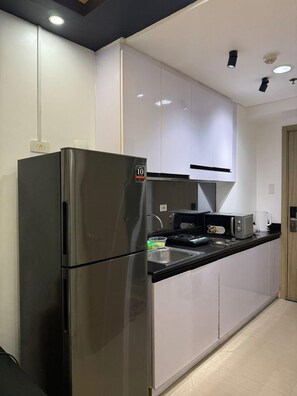 A modern kitchen with a stainless steel refrigerator, a microwave, and a toaster. - 1 BR Unit near MOA SMX WTC NAIA Manila Bay (Pasay City)