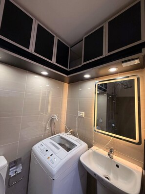 A modern bathroom with a built-in washer, a sink, and a mirror. - 1 BR Unit near MOA SMX WTC NAIA Manila Bay (Pasay City)