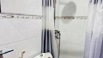 Une salle de bain avec une douche à parois de verre, des toilettes et un lavabo en verre.