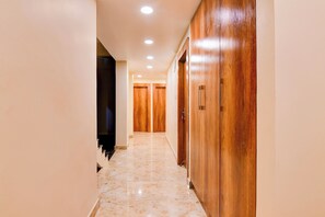 A corridor with wooden doors and a tiled floor. - Hotel O Grand Inn (Barasat)