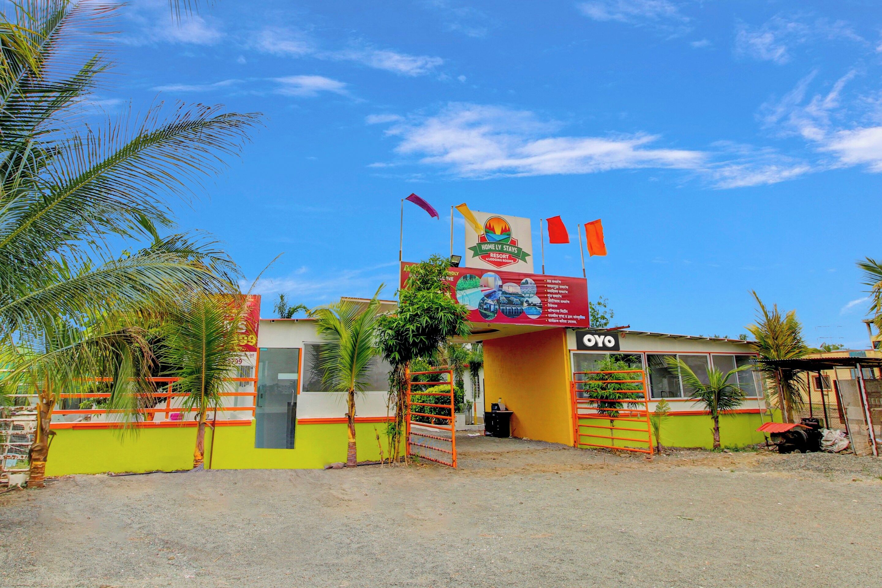 Un resort con un letrero, una entrada vigilada y cielo despejado.
