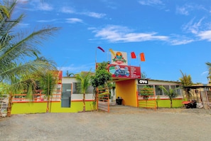 Un resort con un letrero, una entrada vigilada y cielo despejado.