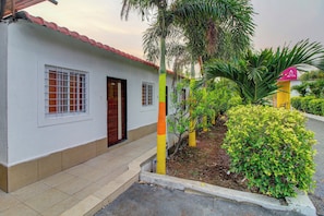 A two-story building with a white exterior, a red-tiled roof, and a small front porch.