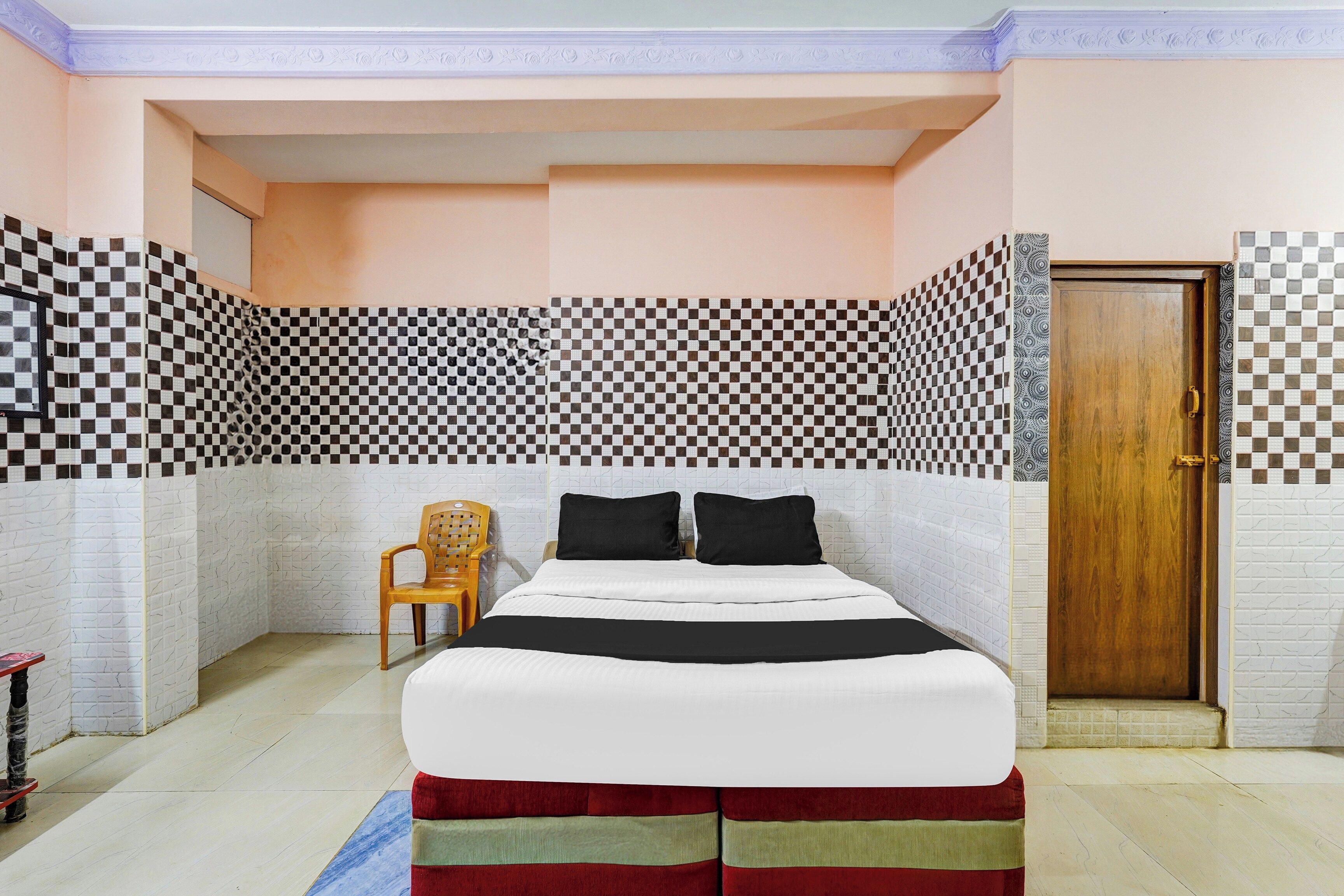 A bedroom with a bed, a wooden door, and patterned walls.