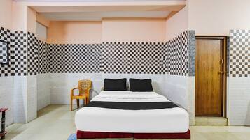 A bedroom with a bed, a wooden door, and patterned walls.