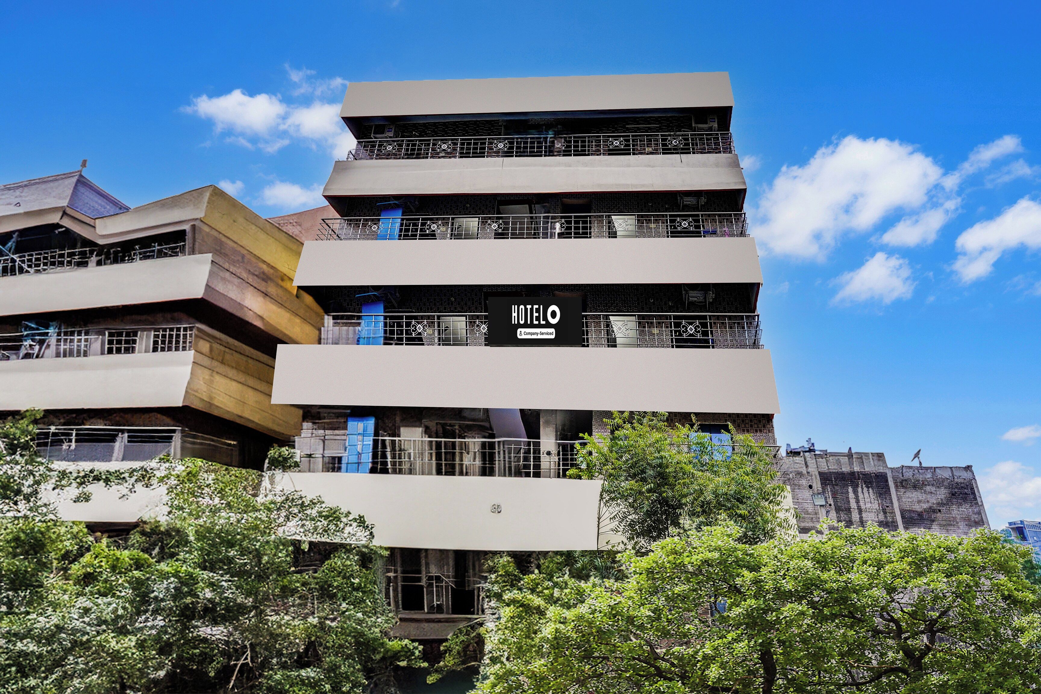Un immeuble à plusieurs étages, sur lequel on peut voir une enseigne bien visible indiquant « HOTELO ».