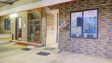 A residential building with a tiled exterior, a gated entrance, and a window with a decorative frame.