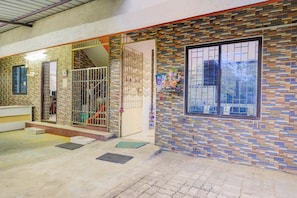 A residential building with a tiled exterior, a gated entrance, and a window with a decorative frame.