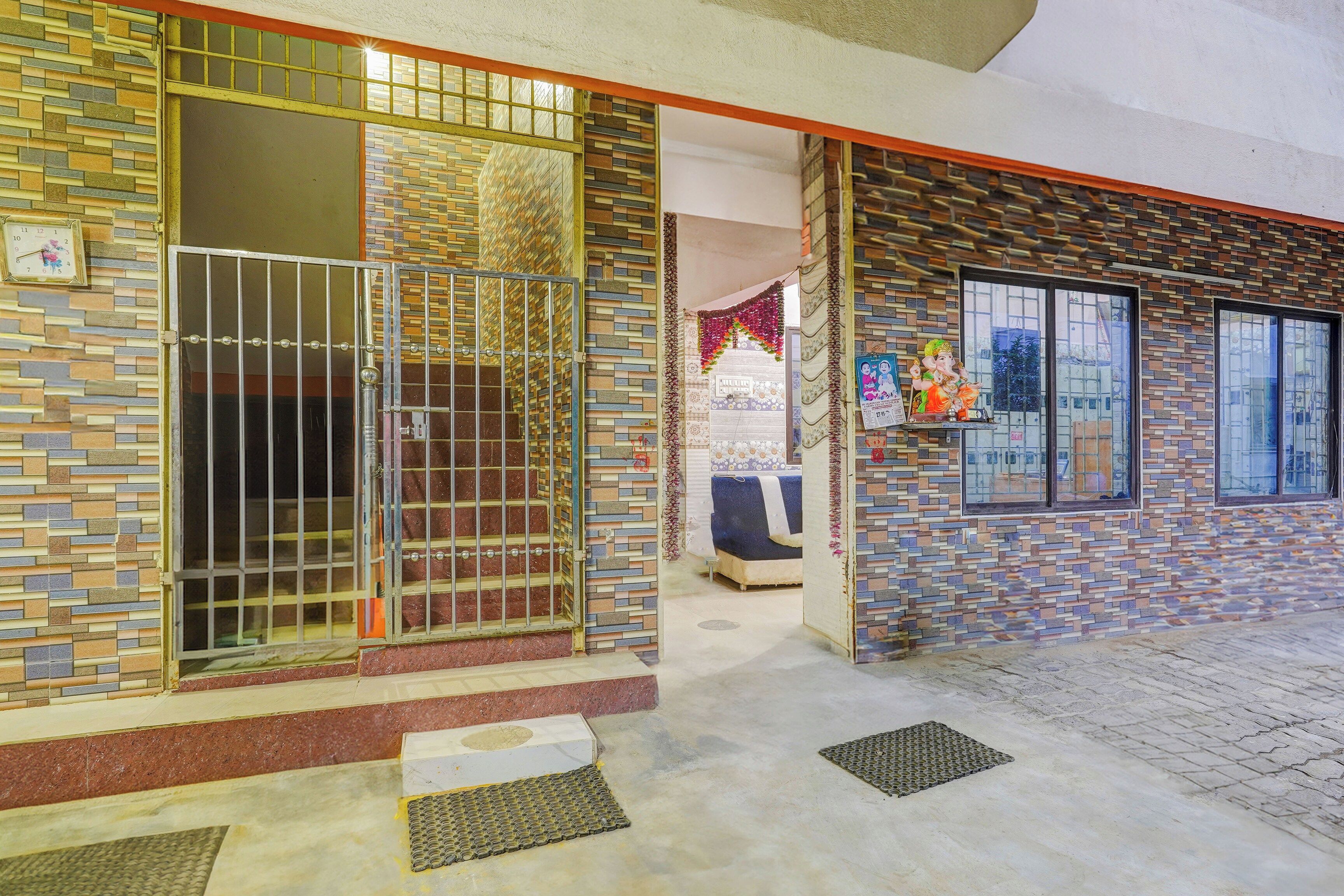 A building with a tiled exterior, a gated entrance, a bed inside, and a statue outside.