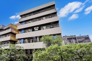 A multi-story hotel with balconies and a sign indicating it is company-serviced.