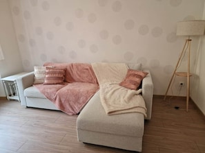 Ein Zimmer mit einer Couch, einer Lampe und einer Wand mit Muster.