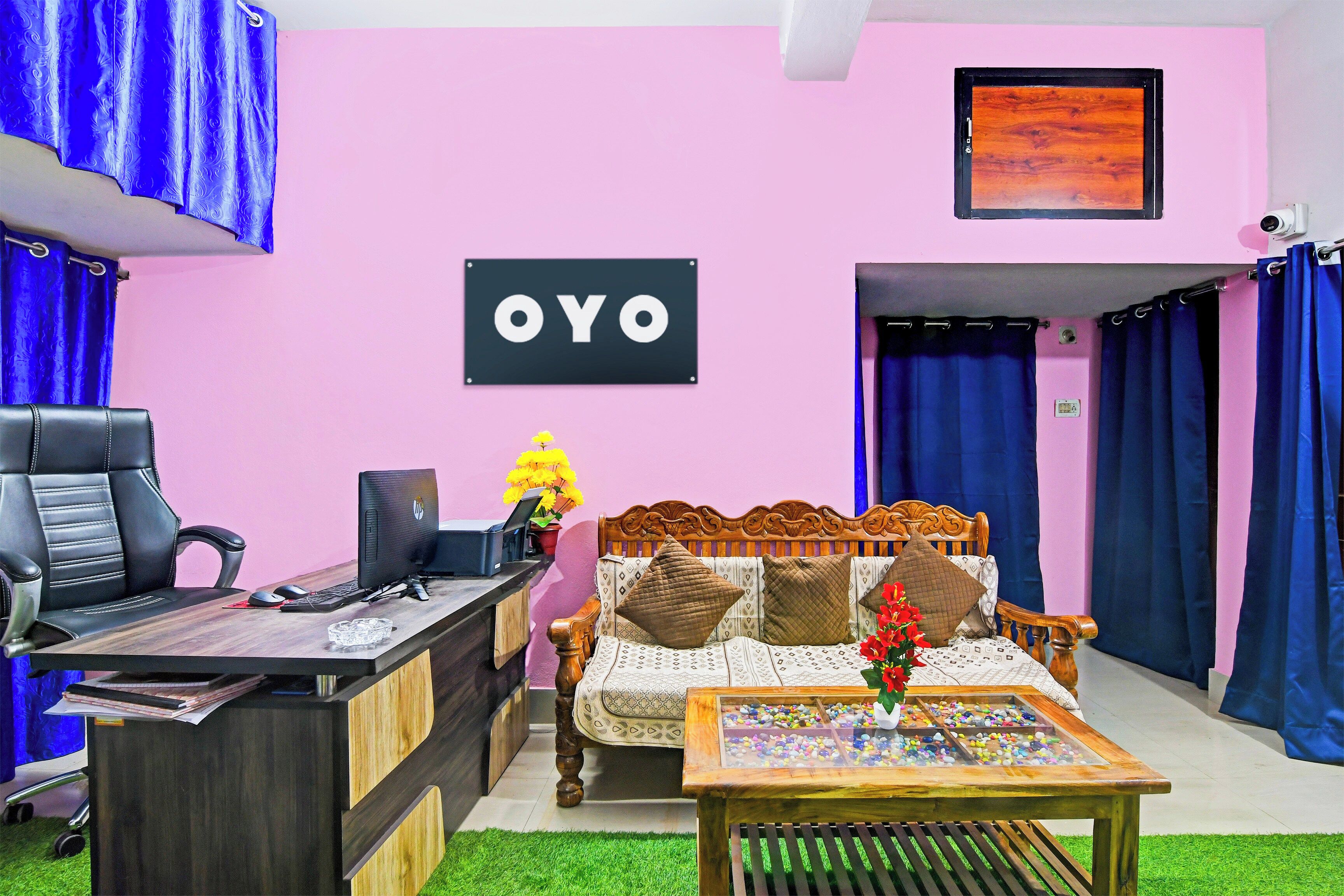 Una habitación con escritorio, silla, cama y un cartel que dice 'OYO'.