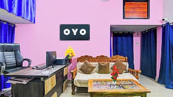 Una habitación con escritorio, silla, cama y un cartel que dice 'OYO'.
