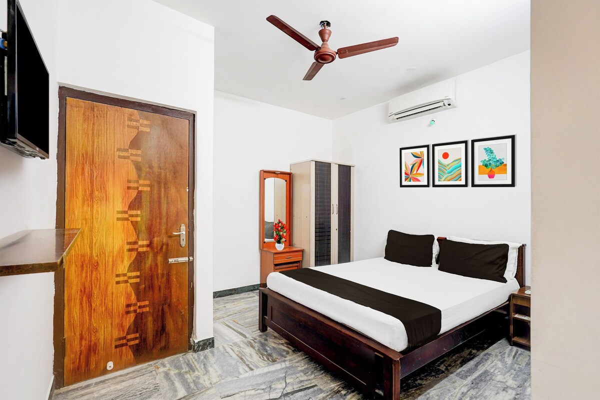 A bedroom with a bed, a wardrobe, a mirror, and a ceiling fan.