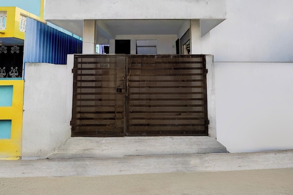 A gated entrance to a building with a concrete ramp leading up to a door. - Hotel O Katpadi Vellore (Vellore)