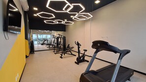 A gym with exercise equipment, including treadmills and weight machines, and a large mirror on the wall. - Nex One Sena Madureira (São Paulo)
