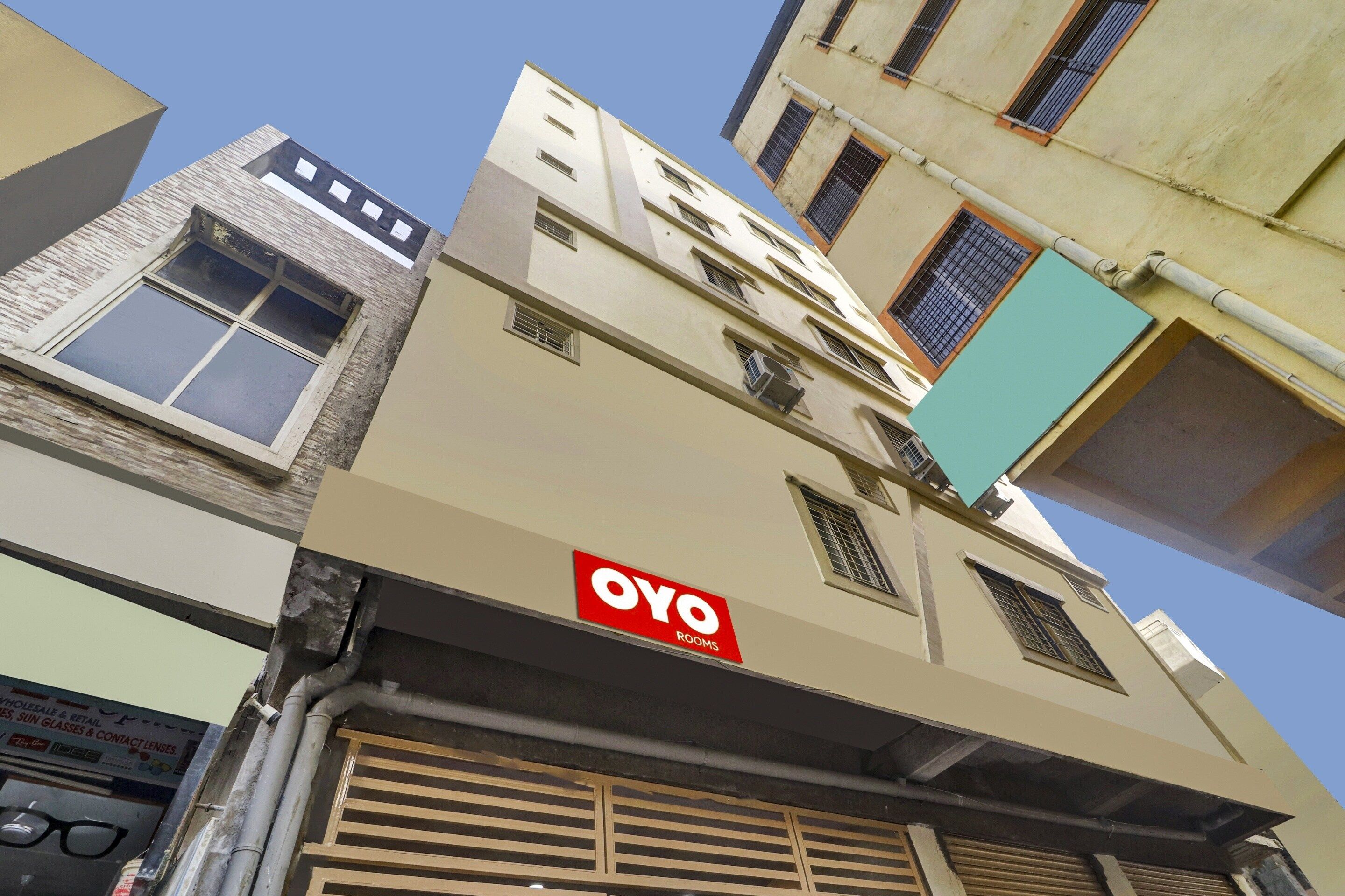 A multi-story building with a sign for 'OYO ROOMS' indicating a hotel or accommodation.