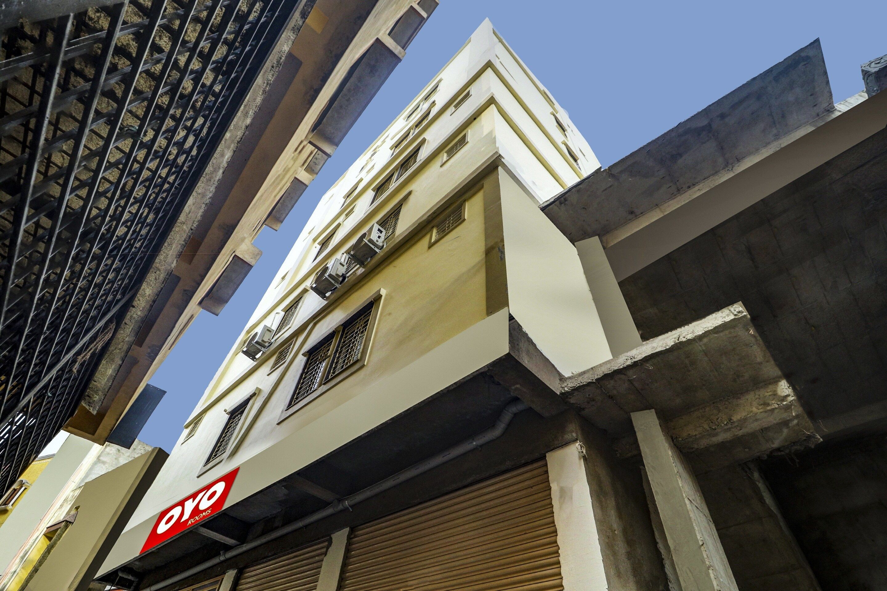 A multi-story building with a visible commercial space on the ground floor, including a sign for 'OYO ROOMS'.