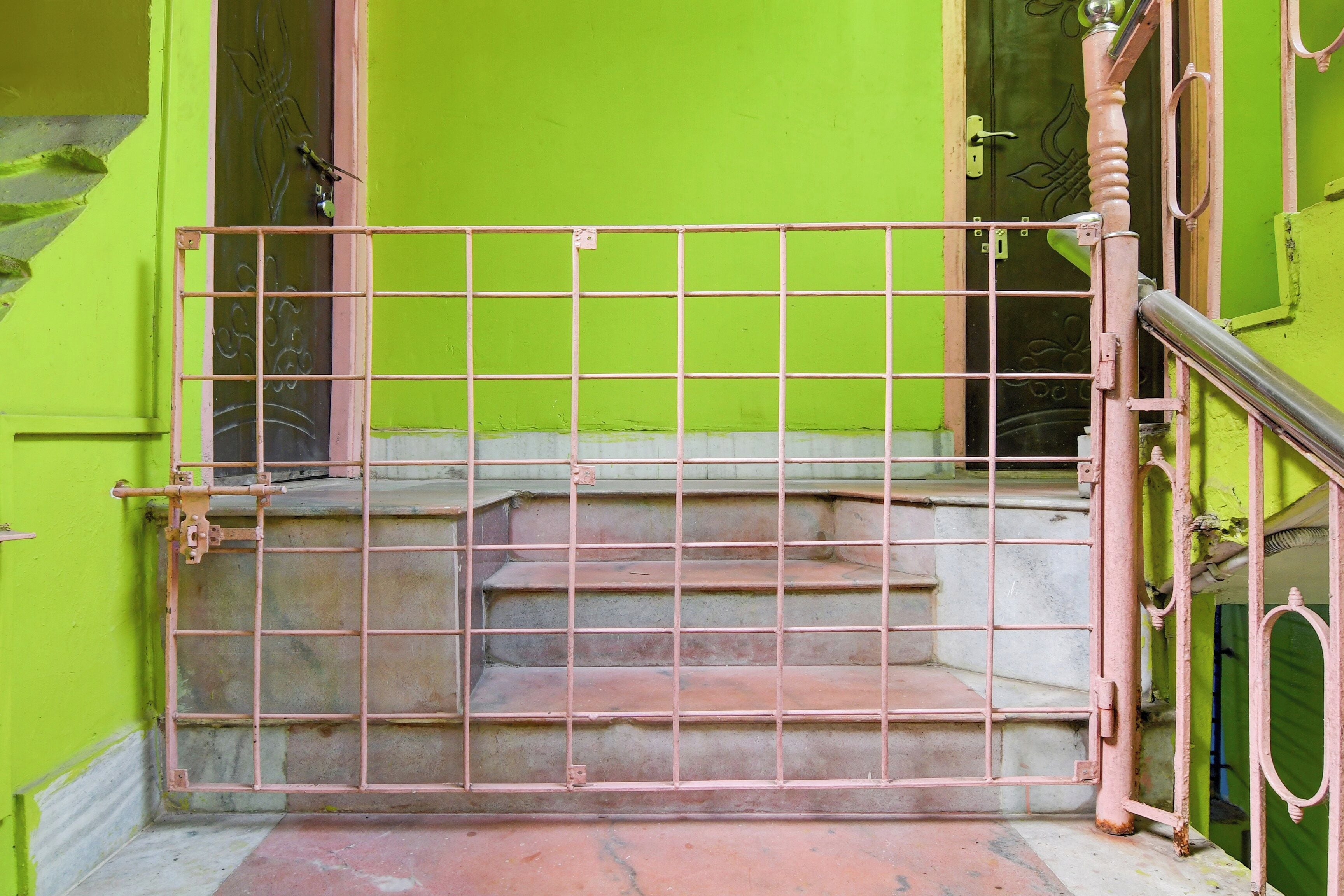Una escalera con una reja metálica, que lleva a una puerta con un ojo de cerradura.