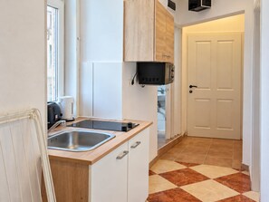 A compact kitchen with a sink, a microwave, and a toaster. - Vienna Calling 1BR near Westbahnhof (Wien)