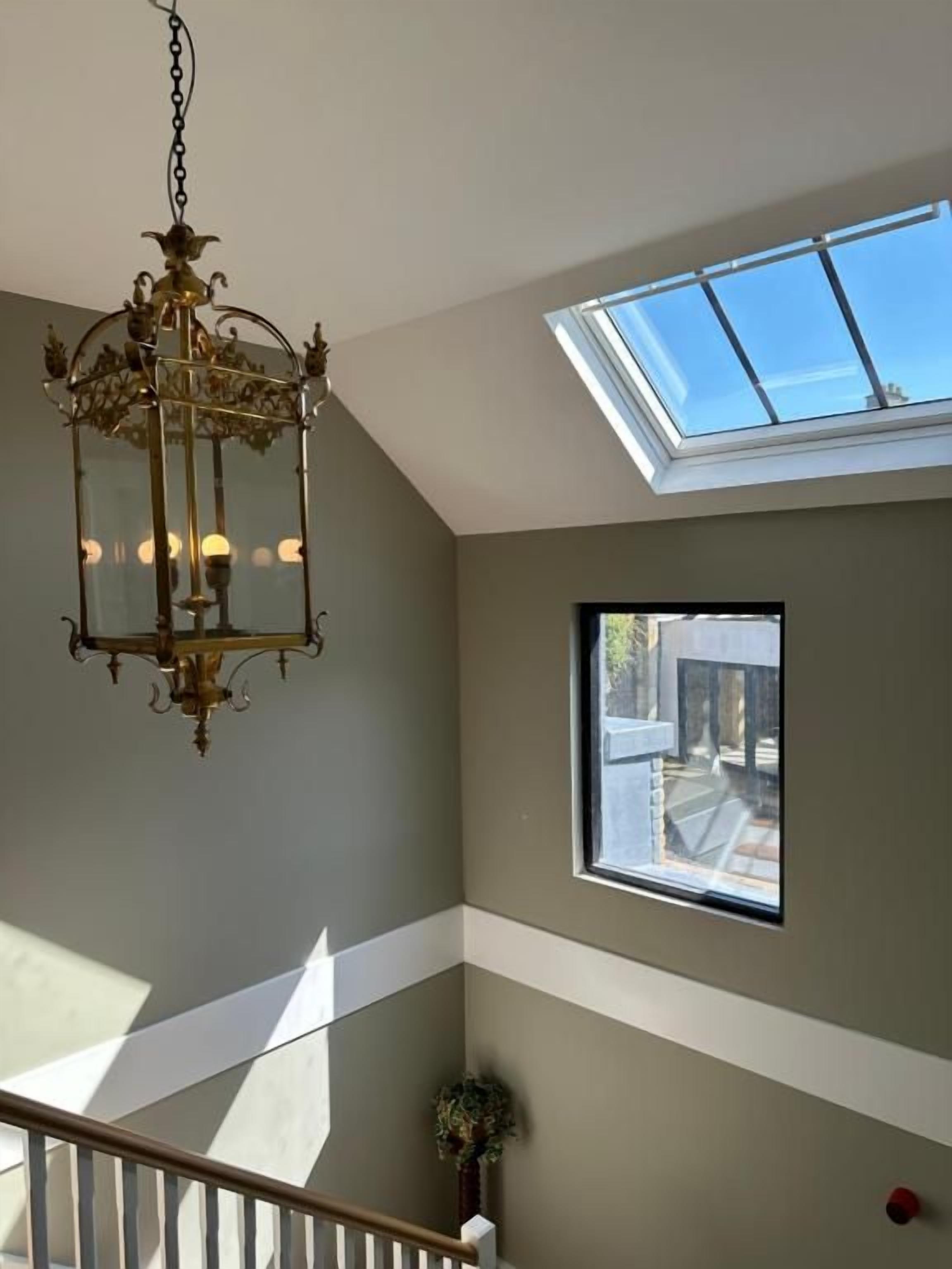 Una habitación con tragaluces, un candelabro y vistas al exterior.