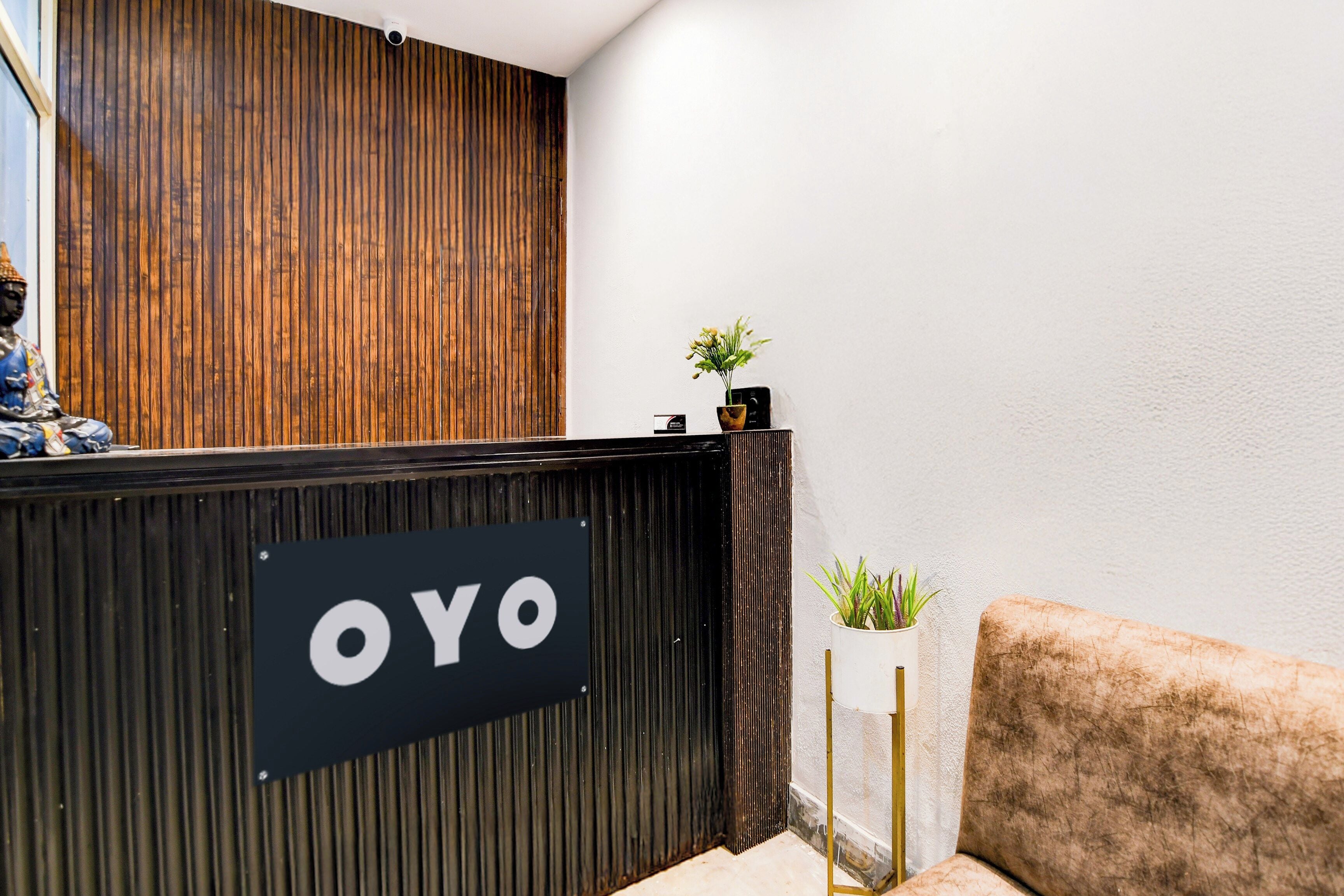 A reception desk with a sign that reads 'OYO' and a small potted plant on top.