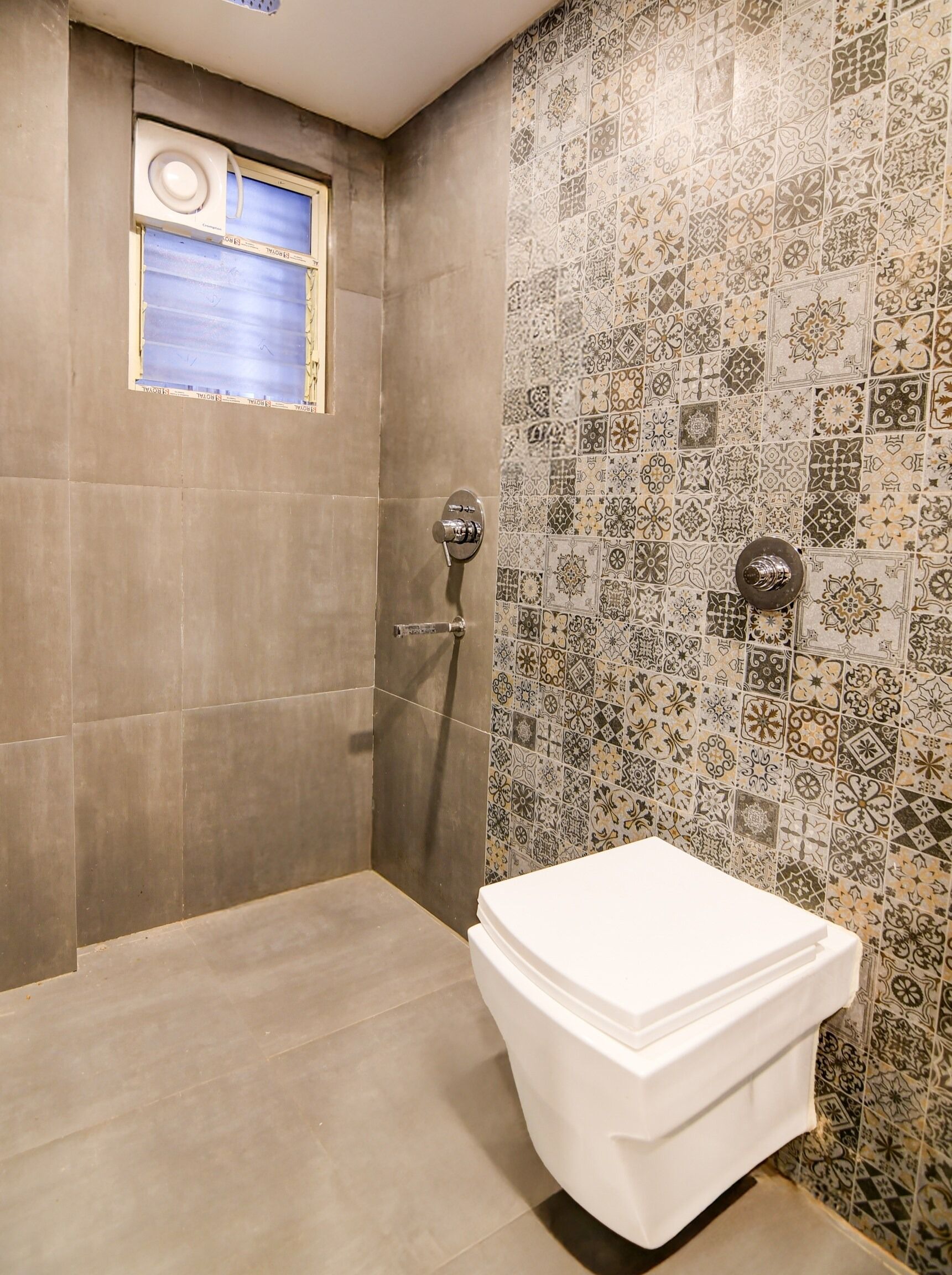 Un baño con ducha, inodoro y ventana.