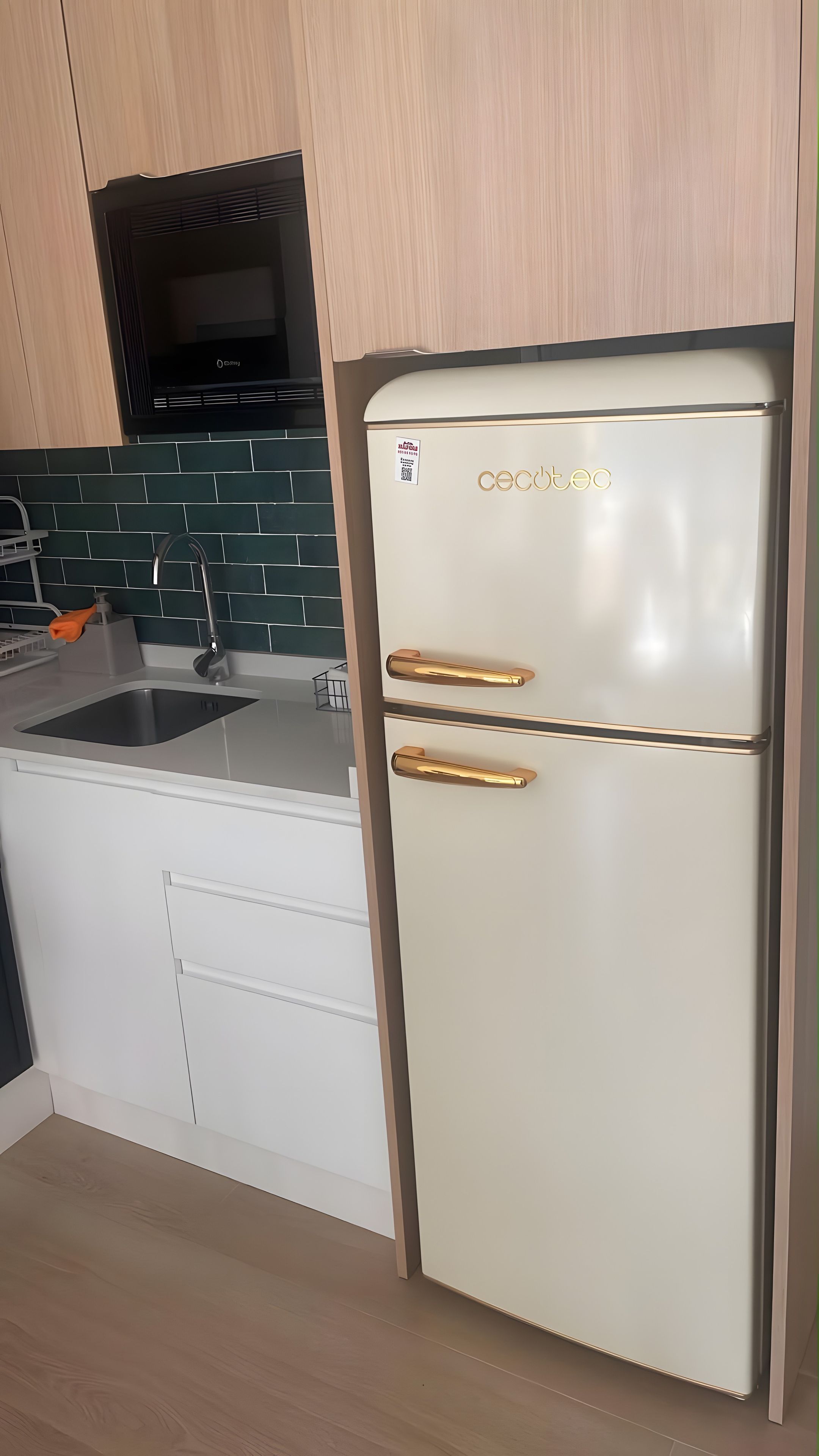 Una cocina con un refrigerador blanco, un lavamanos y una estufa.