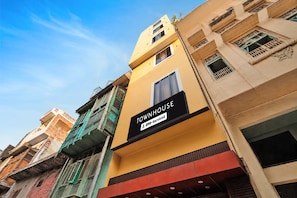Un edificio de varios pisos con un letrero que indica 'TOWNHOUSE' y servicios 'Ovo-Serviced'.