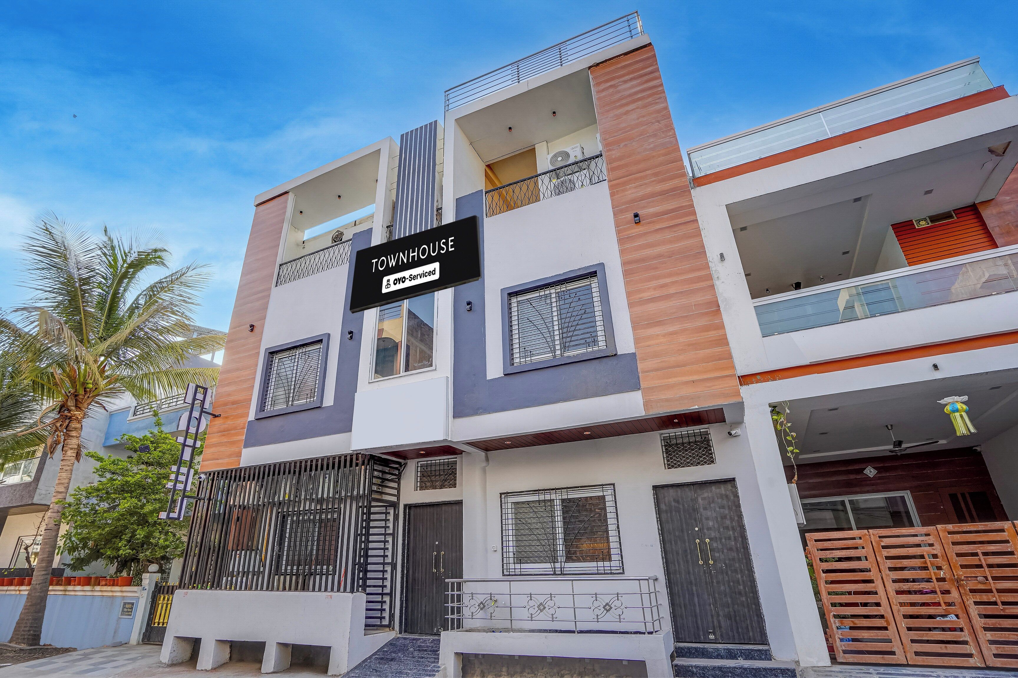 Una casa de apartamentos de varios pisos con un letrero que indica que cuenta con servicios de OYO.
