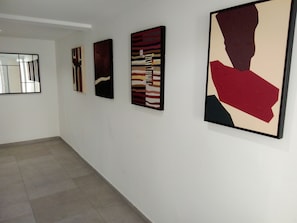 A hallway with four framed artworks on the wall. - New Listing (Port-Vendres)