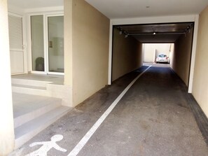 A narrow corridor with a white line marking, a staircase on the left, and a vehicle parked at the end. - New Listing (Port-Vendres)