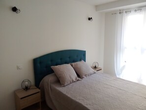 A bedroom with a single bed, a nightstand, a lamp, and a window with curtains. - New Listing (Port-Vendres)