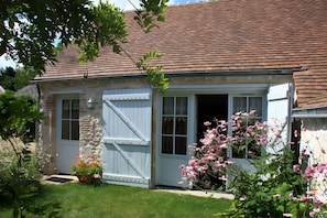 A house with a sloped roof, a white exterior, and a small porch with a white railing. - Holiday Home 'Les Basroches' with Private Terrace, Private Garden and Wi-Fi (Mardié)
