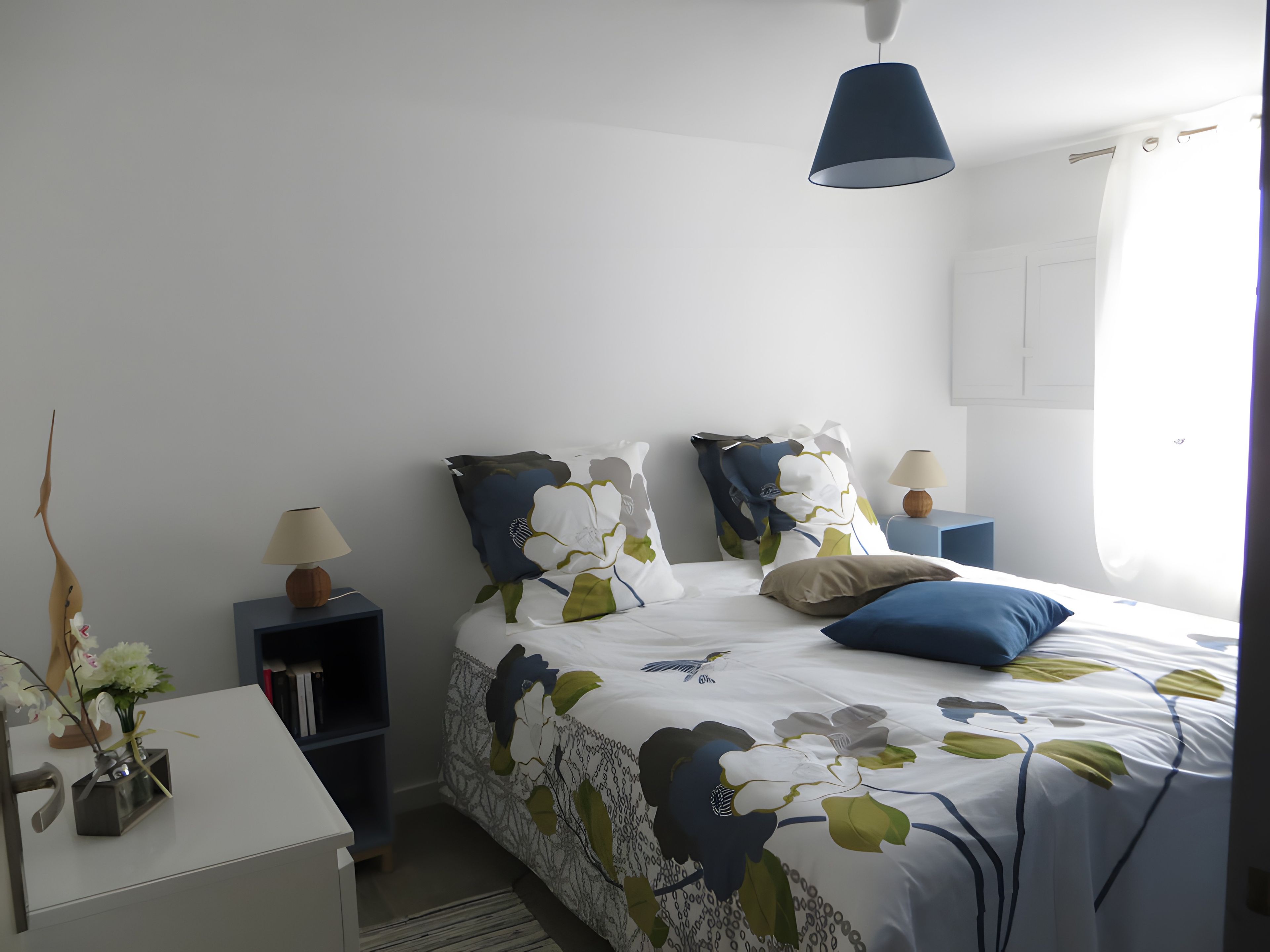 Quarto bem arrumado com cama, mesas de cabeceira e abajur.