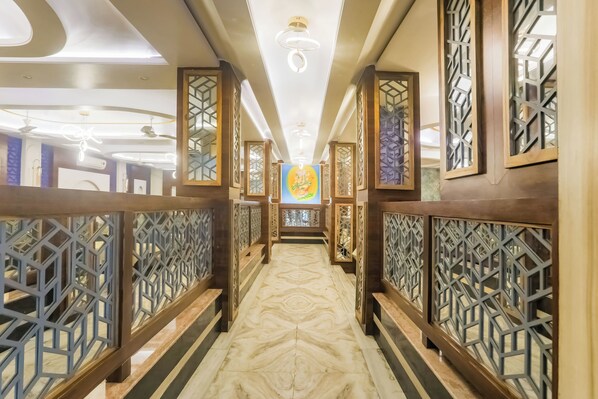 A corridor with patterned wooden railings, a marble floor, and a ceiling with recessed lighting. - Townhouse Jabalpur Railway Junction (Jabalpur)