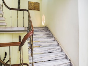 A marble staircase with a wooden handrail and a wall-mounted artwork. - Townhouse Jabalpur Railway Junction (Jabalpur)