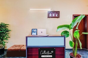 Una recepción con una computadora portátil, un cuadro enmarcado y un cartel que indica 'Empresa de gestión de cobros'.