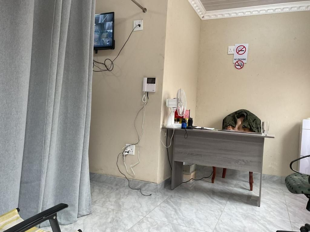 Una habitación con escritorio, silla, televisor montado en la pared y un cartel de 'No Fumar'.