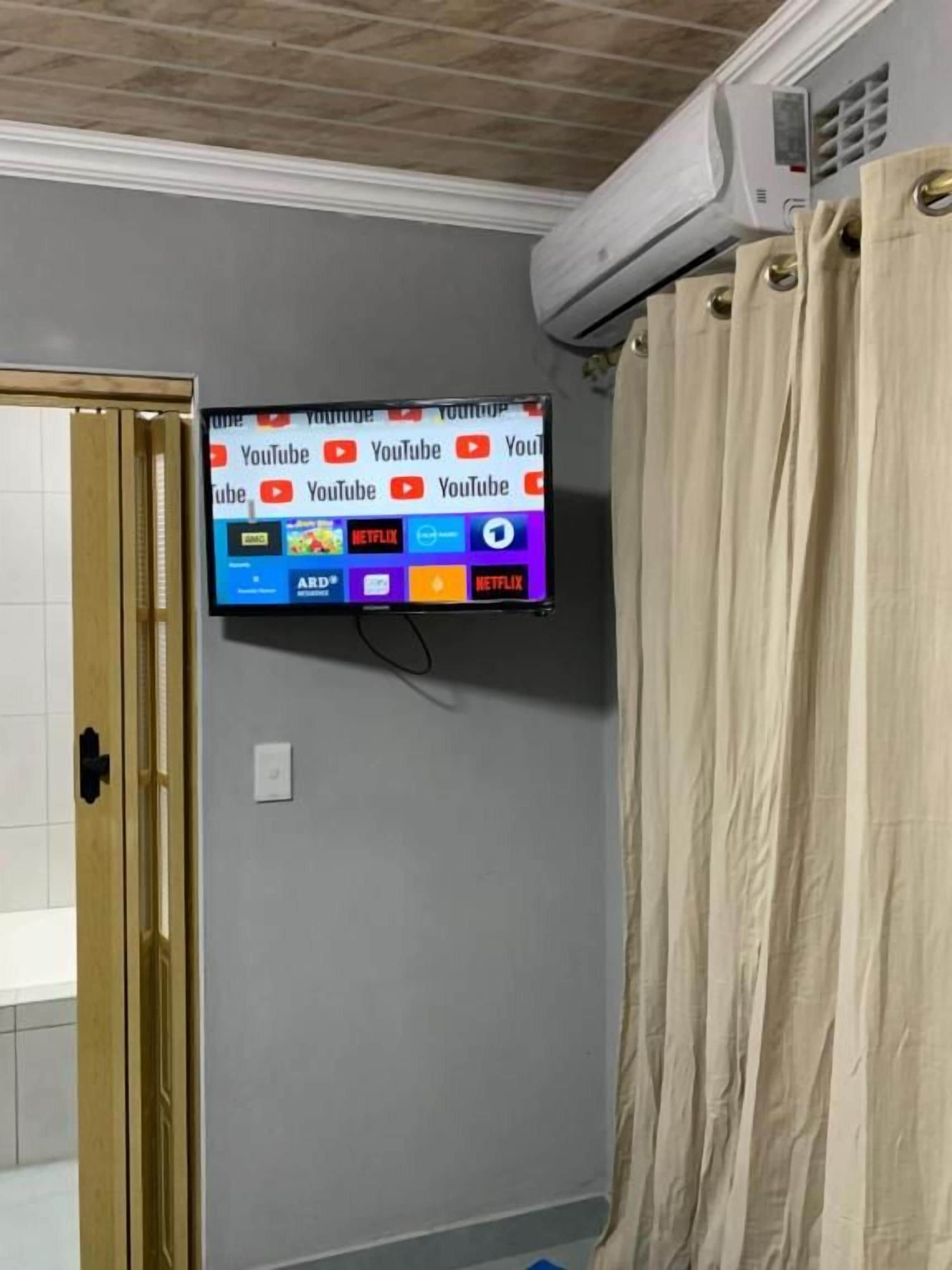 A television mounted on a wall displaying various streaming services.