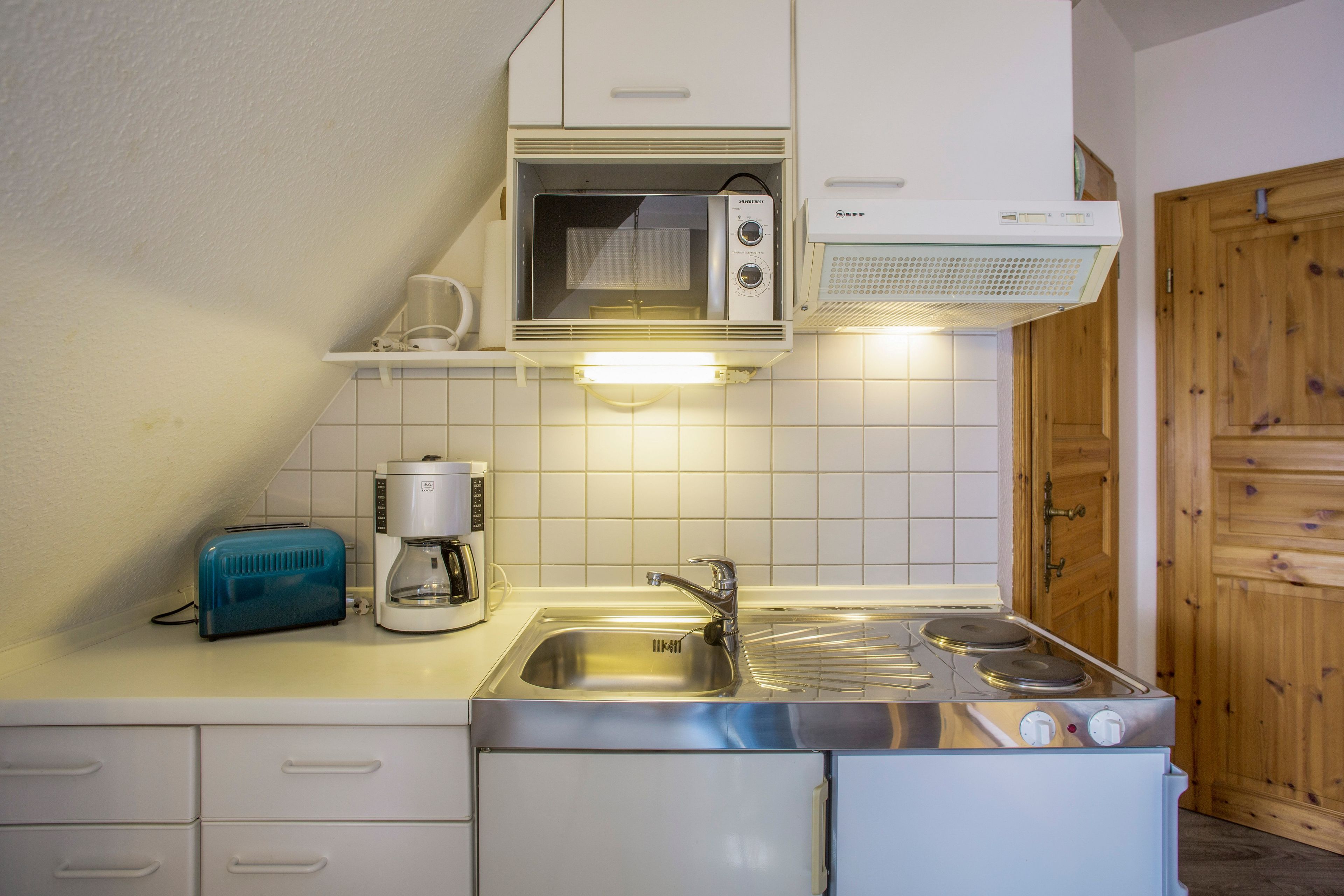 A compact kitchen with a microwave, toaster, and coffee maker.