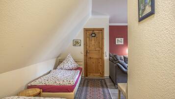 Un corridoio stretto con un letto, un divano e una porta.