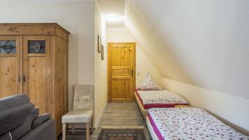 Ein Schlafzimmer mit einem Bett, einem Sessel, einem Kleiderschrank und einer Tür.