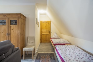 Ein Schlafzimmer mit einem Bett, einem Sessel, einem Kleiderschrank und einer Tür.
