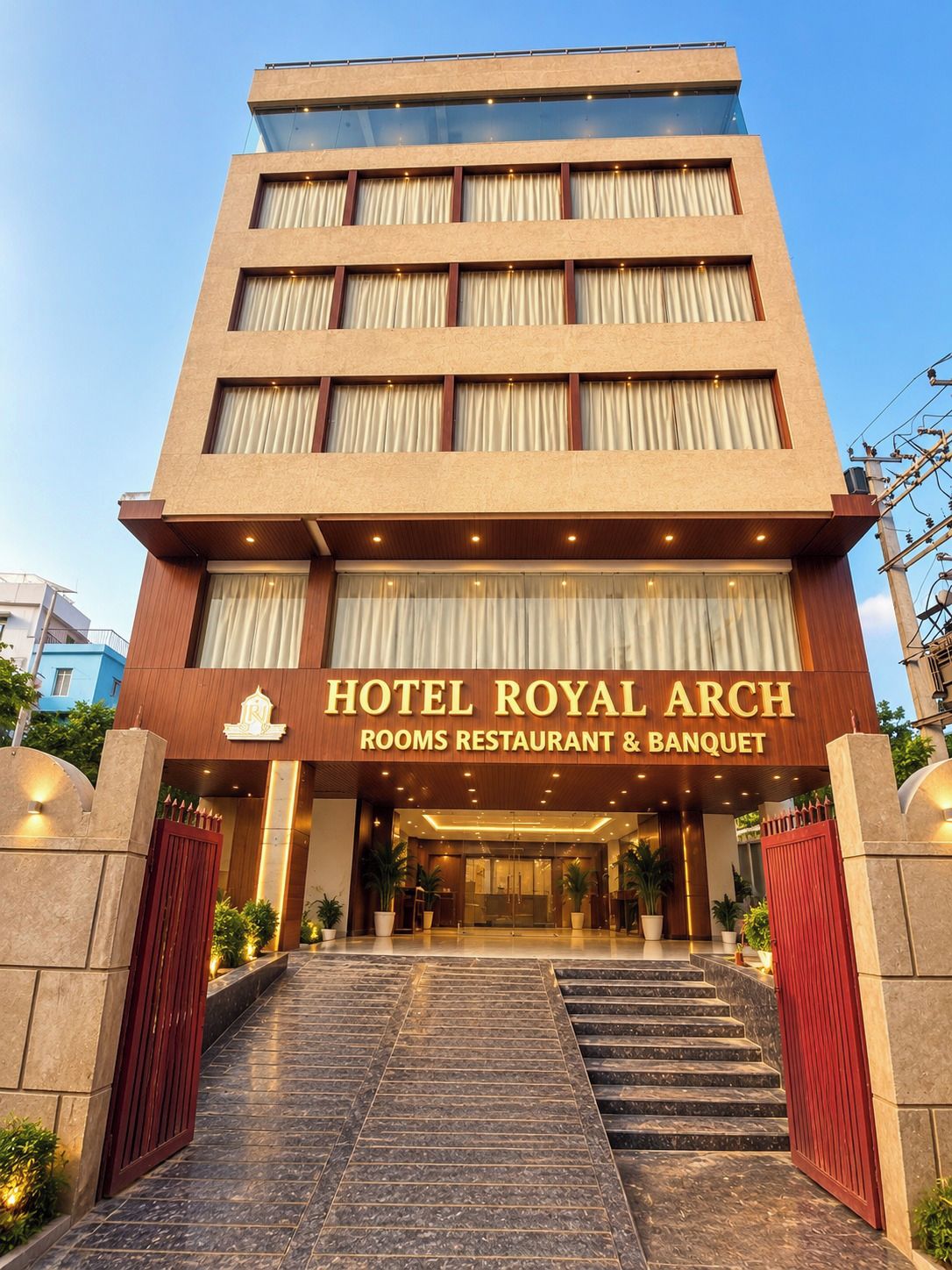 Un hôtel à plusieurs étages, doté d’une entrée imposante, d’une enseigne indiquant qu’il s’agit d’un hôtel, de chambres, d’un restaurant et de salles de réception.