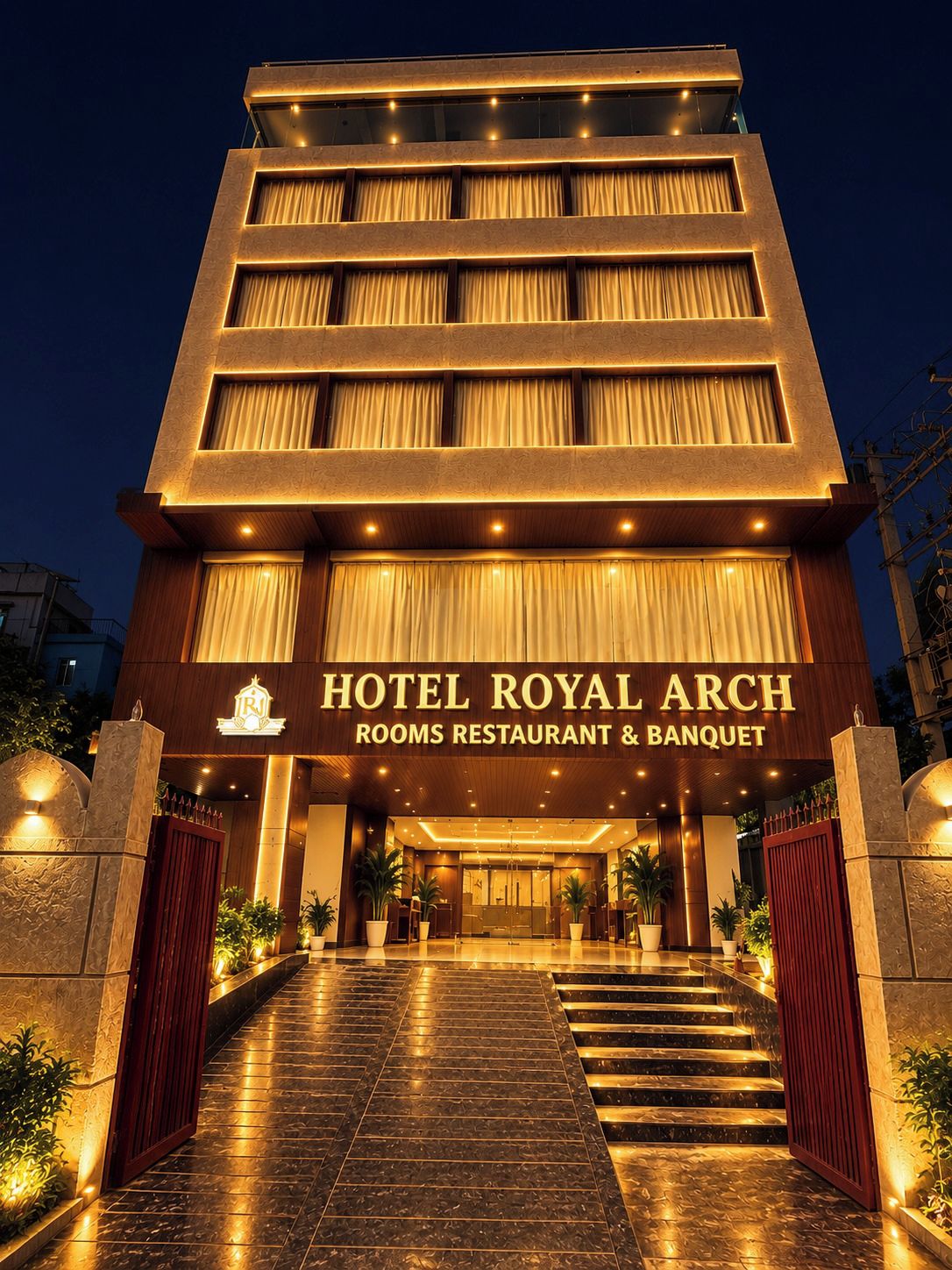 Un hotel de varios pisos con una entrada destacada, que muestra un cartel con la leyenda 'Hotel Royal Arch' y una zona de recepción.